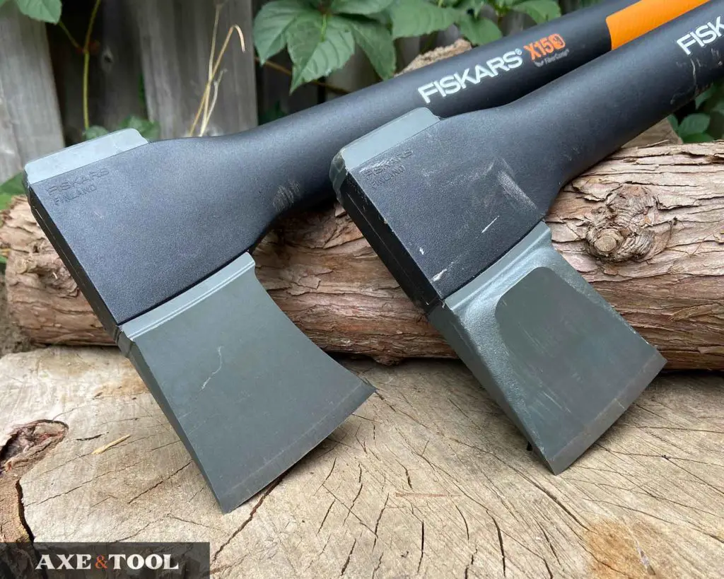 Fiskars chopping axe and splitting axe heads side by side on a log