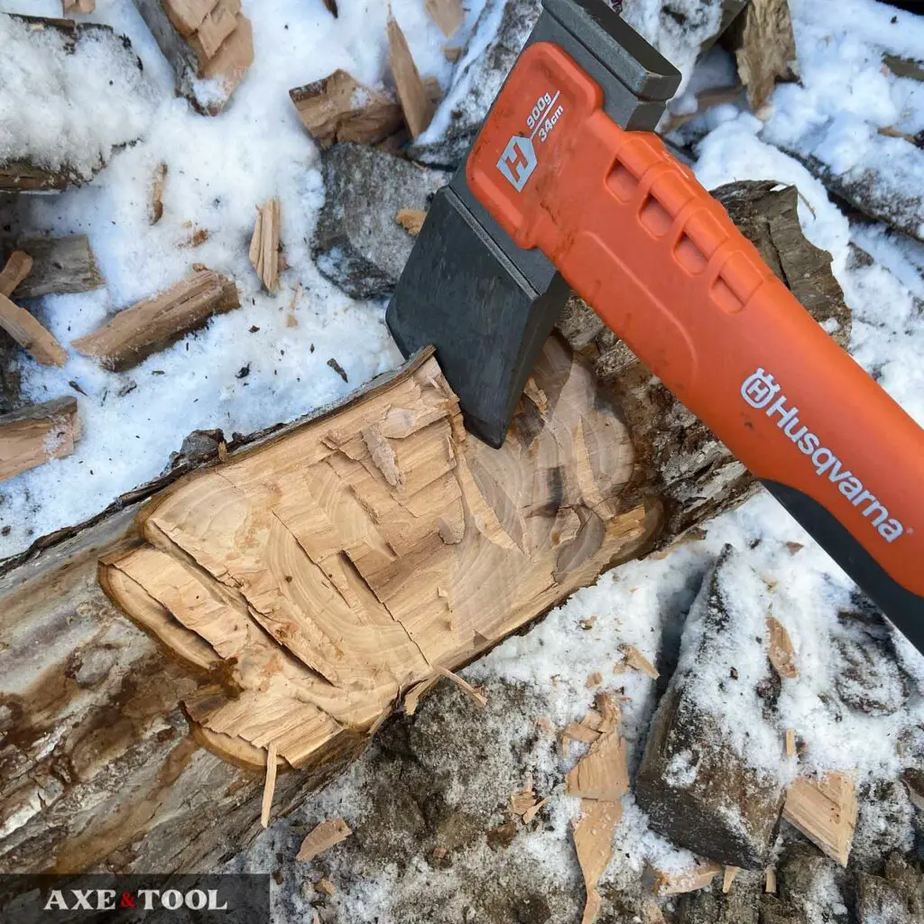 Husqvarna composite hatchet chopping a log in the snow