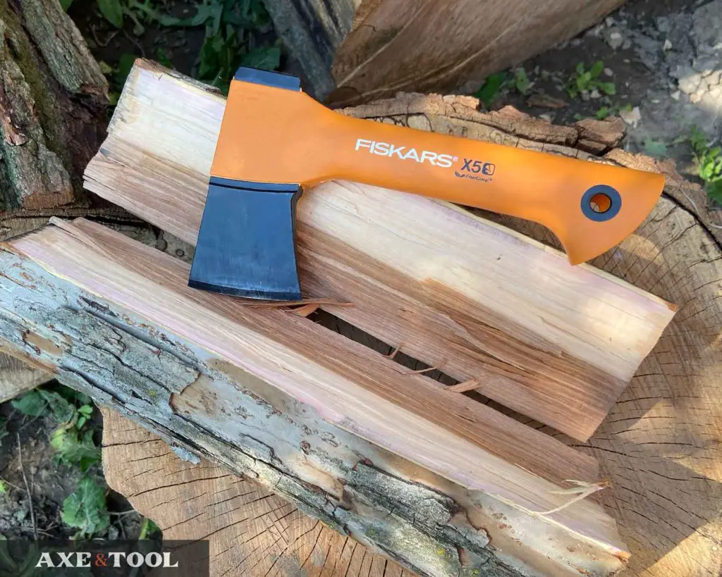 Fiskars X5 mini hatchet in front of a split log