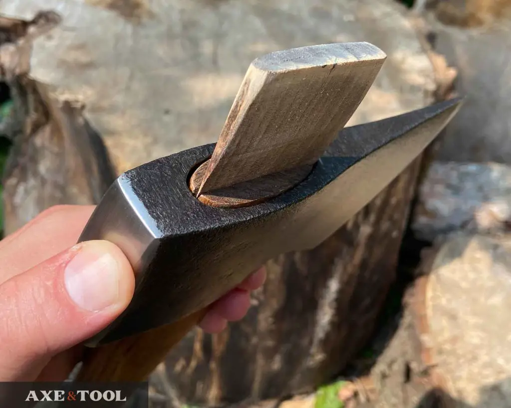 A wood wedge being added to hang an axe and lock the head in place