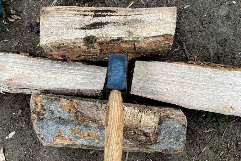 a hatchet splitting wood on a campsite