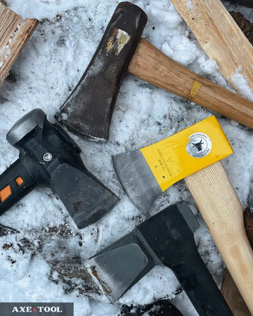 Two splitting axes and two mauls on a chopping block in the snow. 